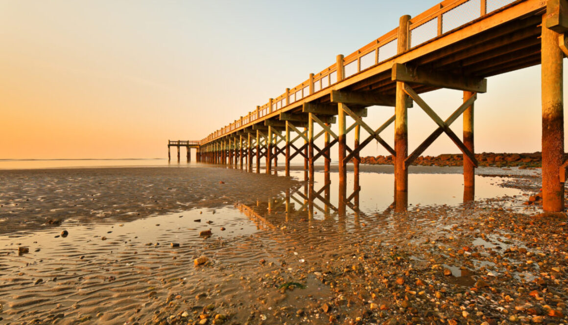 Overview of beautiful fishing pier after sunset at low tide at Walnut Beach, Milford Connecticut, USA.