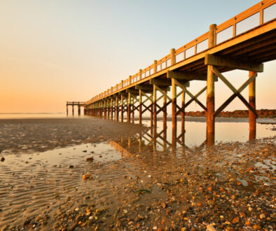 Overview of beautiful fishing pier after sunset at low tide at Walnut Beach, Milford Connecticut, USA.