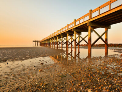 Overview of beautiful fishing pier after sunset at low tide at Walnut Beach, Milford Connecticut, USA.