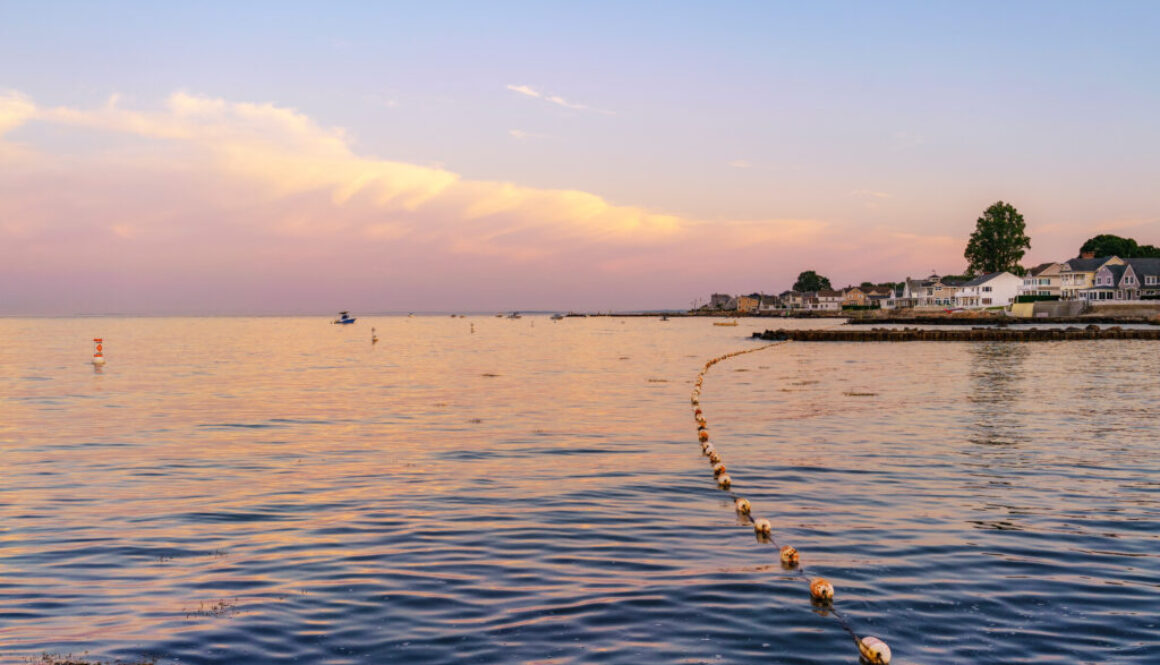 Black Point Beach, Niantic, East Lyme, Connecticut blue hour with a pastel sky and clouds view across the water with pink and purple reflections on the sea, July 2018.