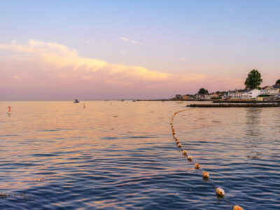 Black Point Beach, Niantic, East Lyme, Connecticut blue hour with a pastel sky and clouds view across the water with pink and purple reflections on the sea, July 2018.