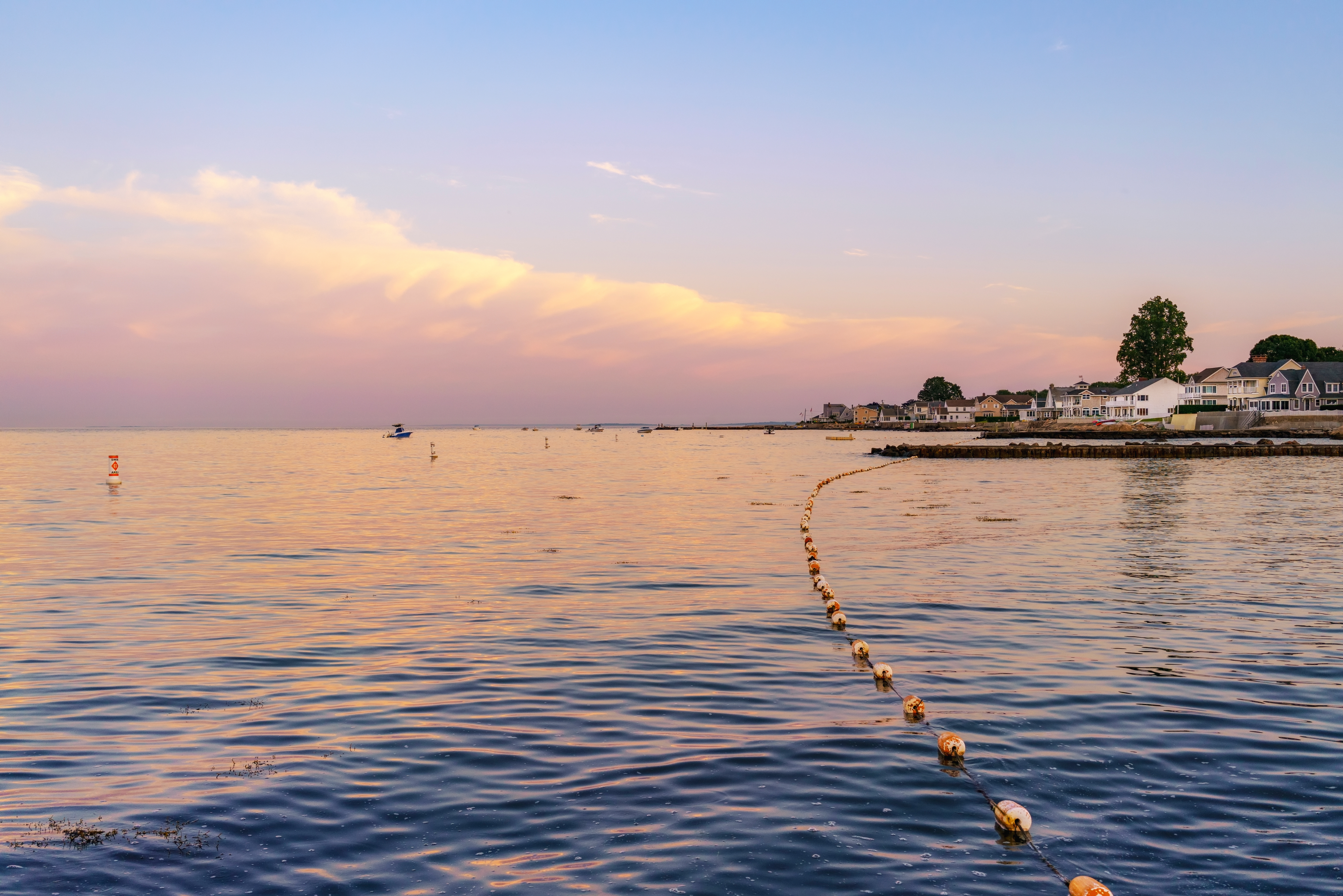 Black Point Beach, Niantic, East Lyme, Connecticut blue hour with a pastel sky and clouds view across the water with pink and purple reflections on the sea, July 2018.