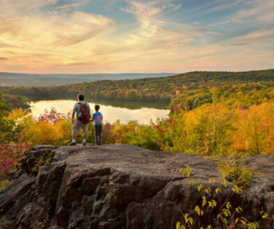 father and son hike to a beautiful overlook in the fall