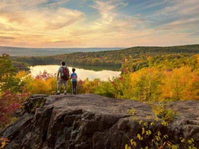 father and son hike to a beautiful overlook in the fall