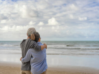 The elderly couples embraced at the seaside.The elderly couples embraced at the seaside.An old couple hugged by the sea.Mature couples relax at the seaside on holiday.