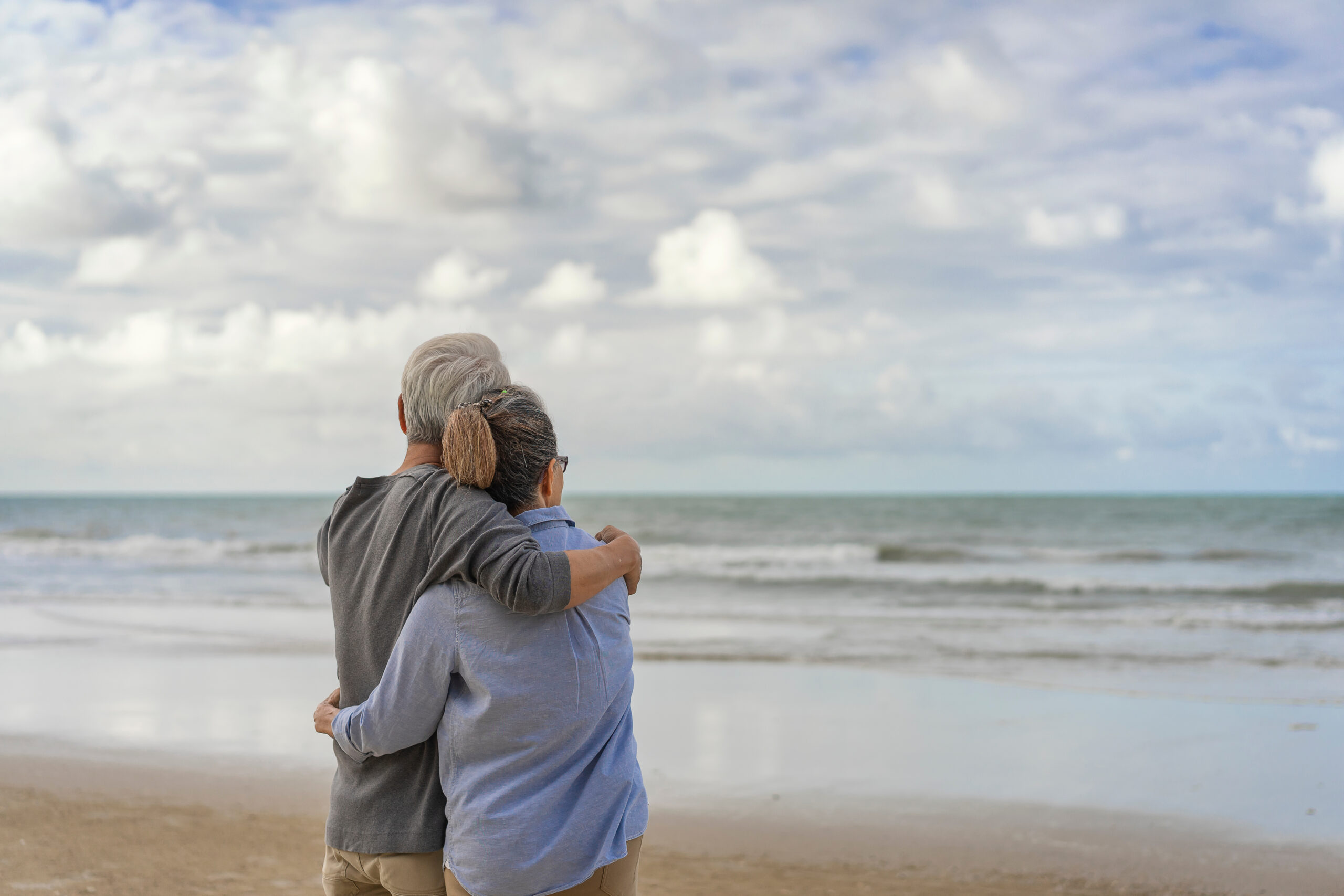The elderly couples embraced at the seaside.The elderly couples embraced at the seaside.An old couple hugged by the sea.Mature couples relax at the seaside on holiday.