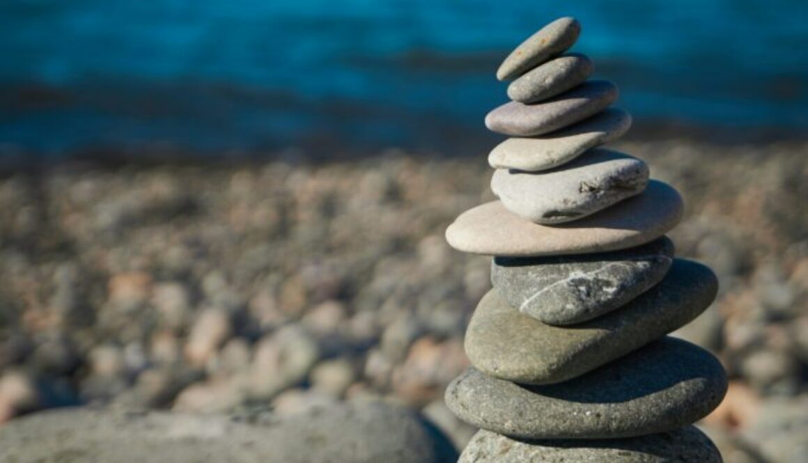 rocks balancing on top of one another, representing work-life balance tension and time management for business owners