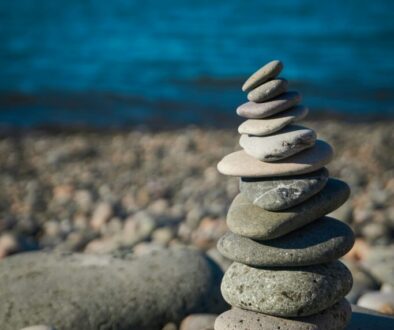 rocks balancing on top of one another, representing work-life balance tension and time management for business owners